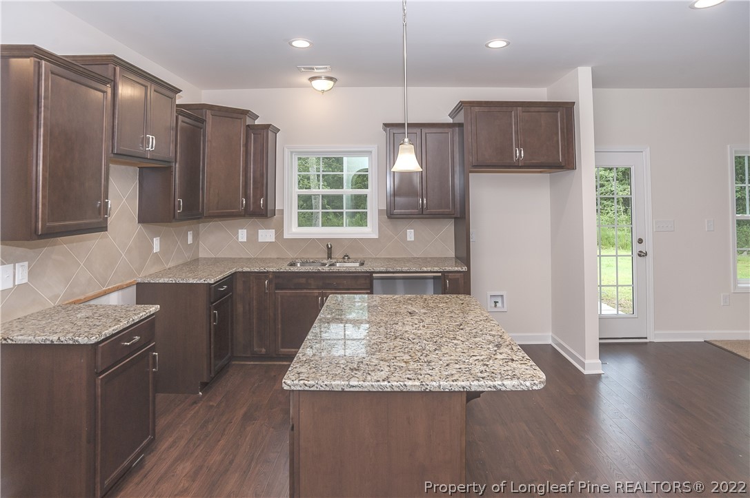 312 Mill Ridge Court Godwin, NC 28344 - Photo 7 of 32 a kitchen with kitchen island granite countertop a sink a counter top space and stainless steel appliances