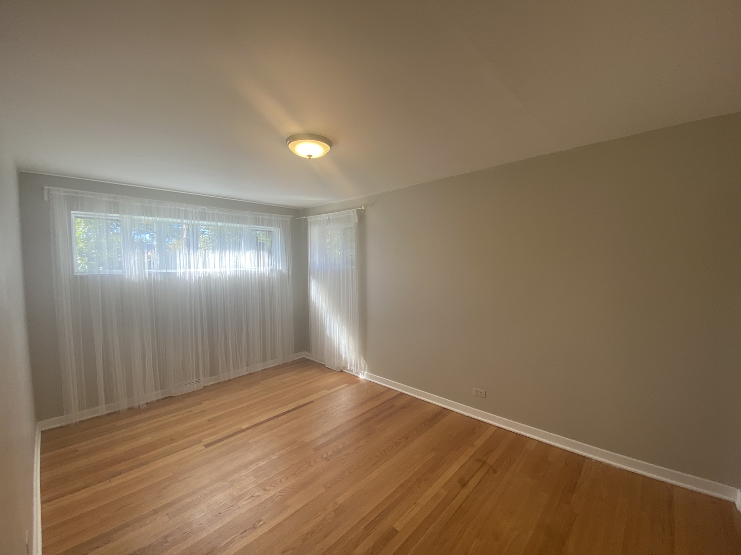 1025 South Dee Road Park Ridge, IL 60068 - Photo 8 of 13 an empty room with wooden floor and windows in a room
