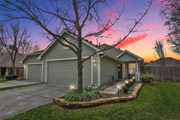 a backyard of a house with plants and large tree