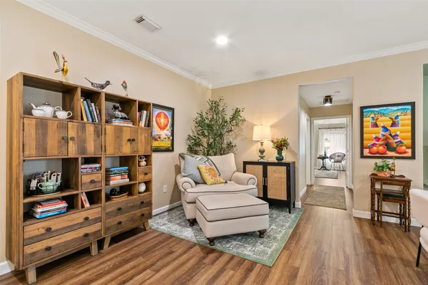 a living room with furniture a rug and a book shelf