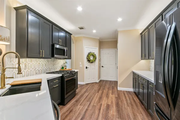 a kitchen with stainless steel appliances granite countertop a stove a sink and a refrigerator