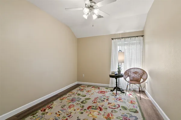 a room with gym equipment and wooden floor