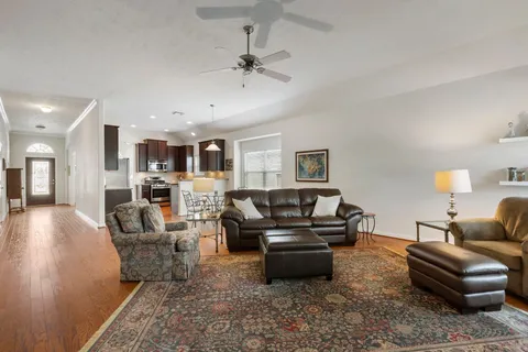 a living room with furniture and a view of kitchen