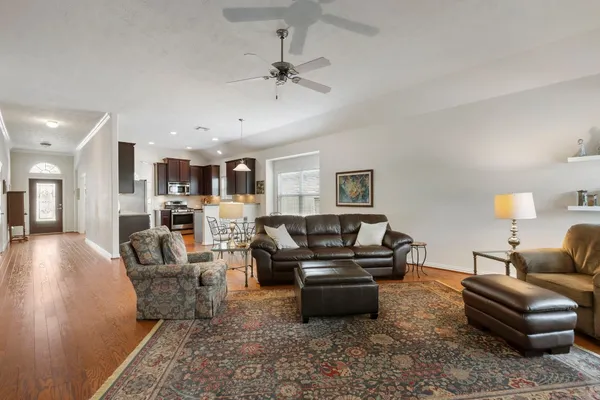 a living room with furniture and a view of kitchen