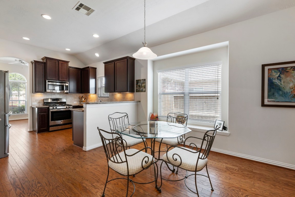 3214 Clover Trace Drive Spring, TX 77386 - Photo 13 of 48 a kitchen with stainless steel appliances a dining table chairs stove and refrigerator