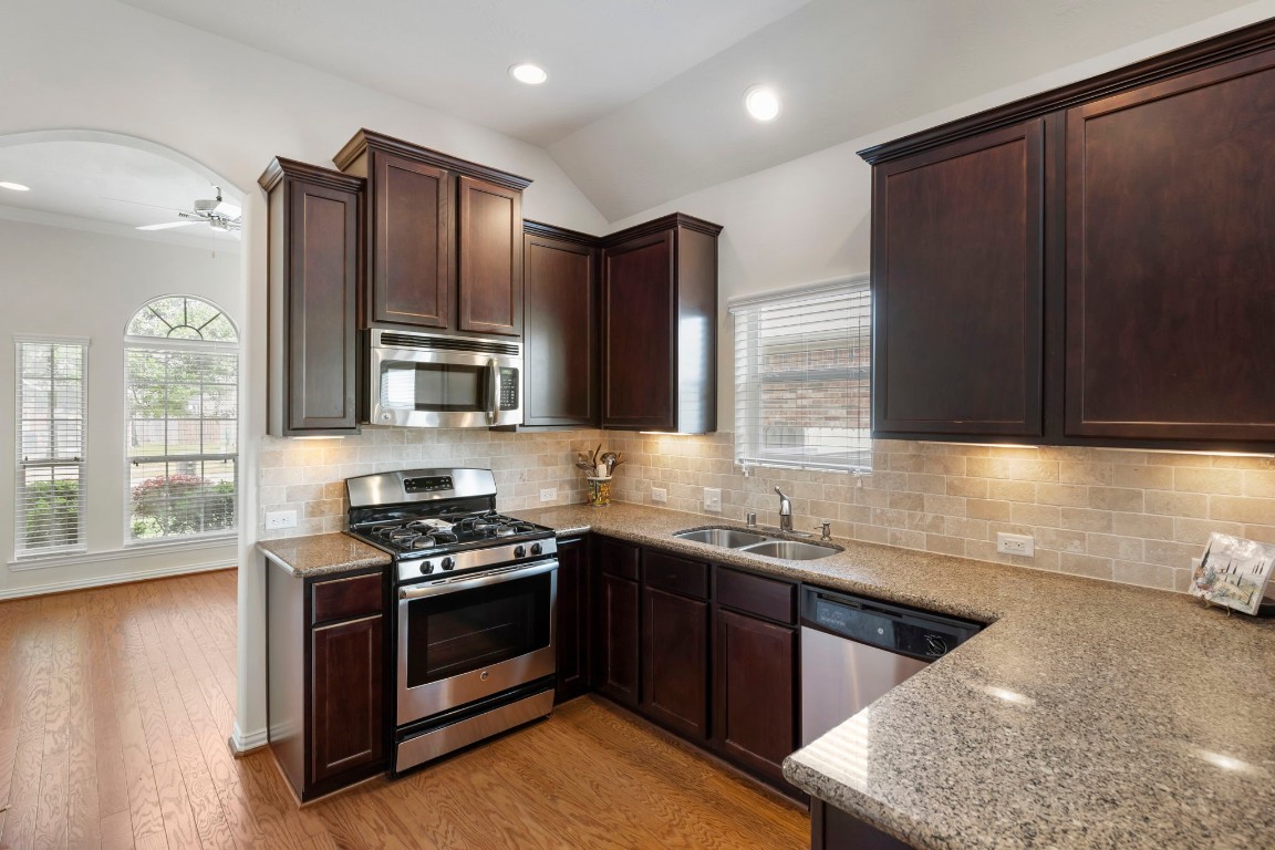 3214 Clover Trace Drive Spring, TX 77386 - Photo 17 of 48 a kitchen with stainless steel appliances wooden cabinets and a stove top oven