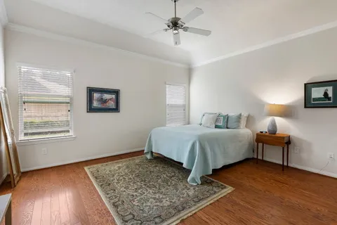 a bedroom with a bed lamps and wooden floor
