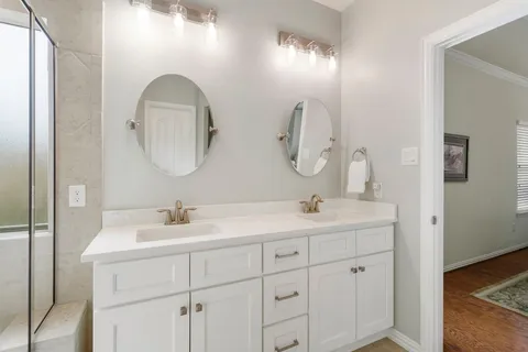 a bathroom with a double vanity sink and a mirror