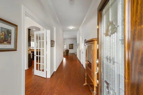 a view of a hallway with wooden floor and windows