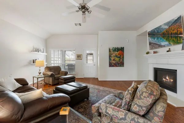 a living room with furniture a flat screen tv and a fireplace