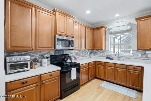 a kitchen with stainless steel appliances granite countertop a sink stove and microwave