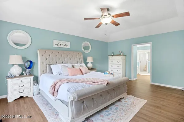 a bedroom with a large bed and a chandelier