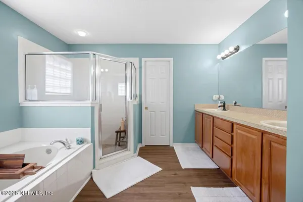 a spacious bathroom with a tub sink and mirror
