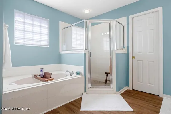 a bathroom with a tub shower and a window