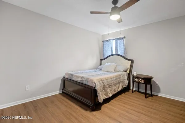a bedroom with a bed and wooden floor