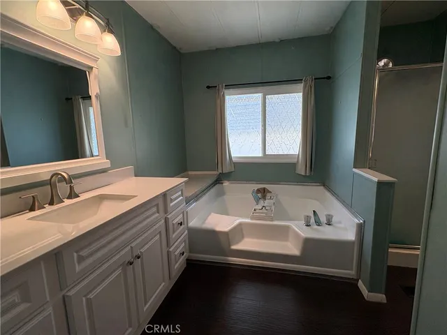 a kitchen with kitchen island stainless steel appliances a sink a stove a refrigerator cabinets and a dining table