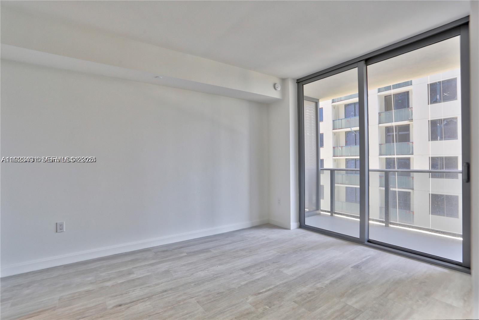 55 Southwest 9th Street, Unit 1910 Miami, FL 33130 - Photo 4 of 11 a view of a room with wooden floor and windows