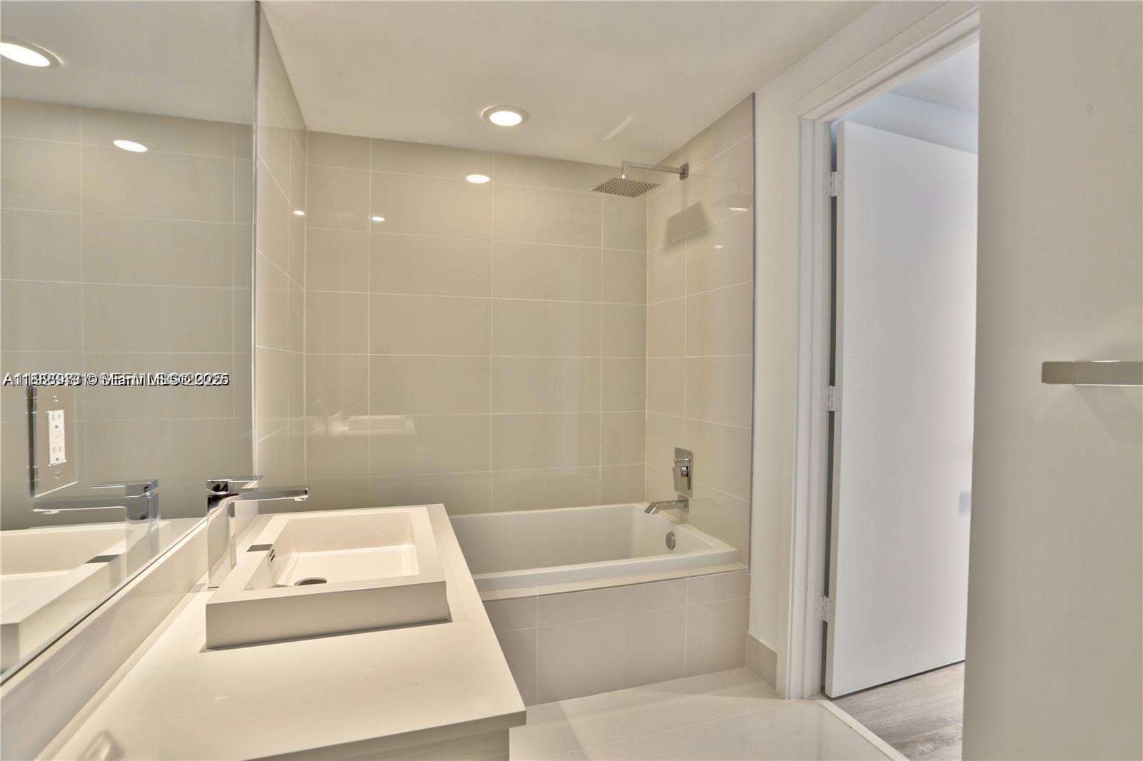 55 Southwest 9th Street, Unit 1910 Miami, FL 33130 - Photo 7 of 11 a bathroom with a bathtub shower sink and toilet