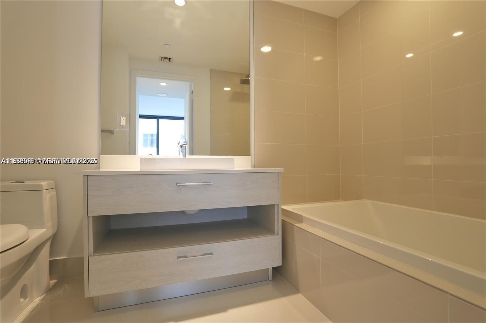 55 Southwest 9th Street, Unit 1910 Miami, FL 33130 - Photo 8 of 11 a bathroom with a sink a toilet and a bathtub
