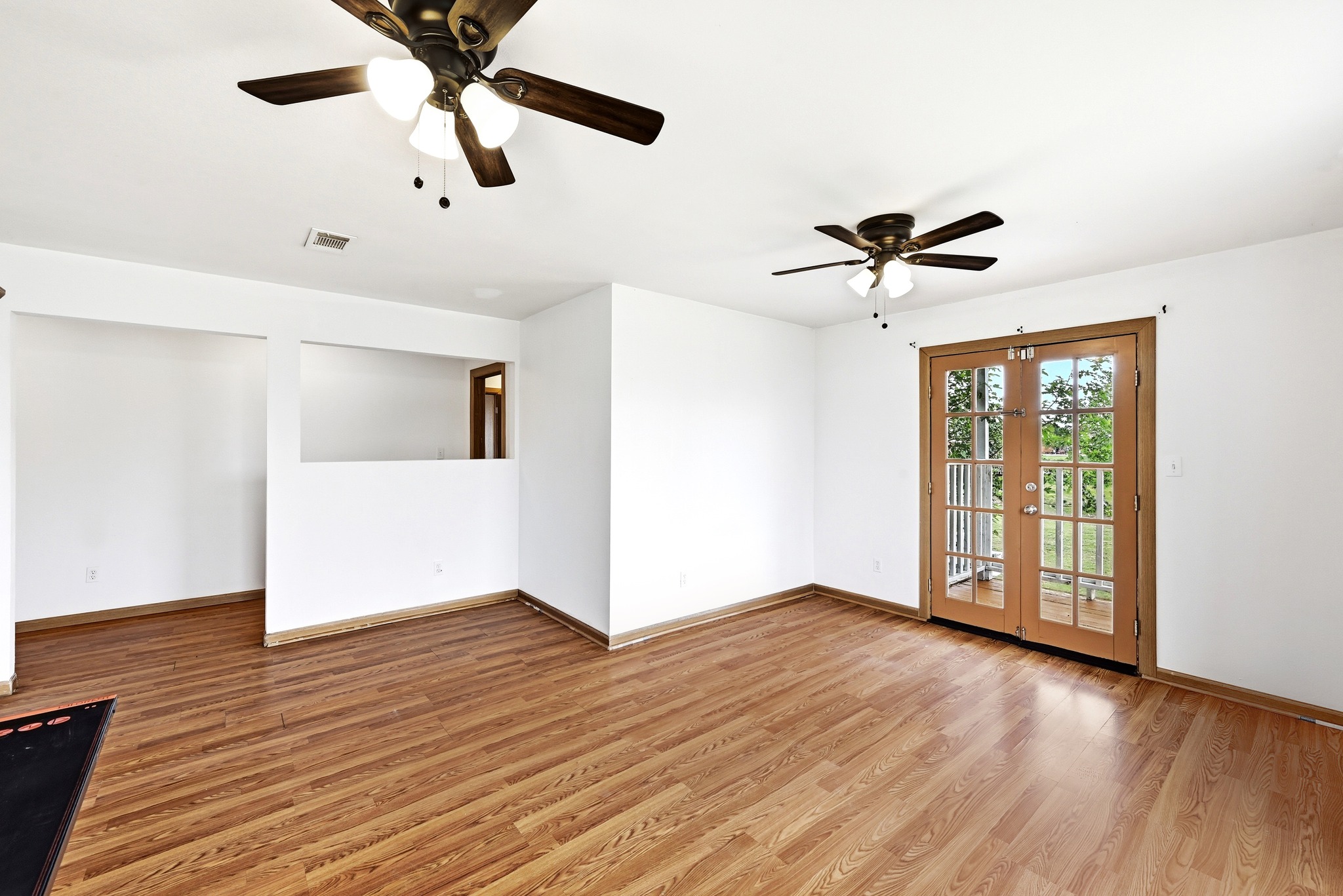 320 Sunset Ridge Maxwell, TX 78656 - Photo 23 of 32 a view of an empty room with wooden floor and a ceiling fan
