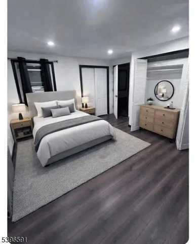 a spacious bedroom with a bed a mirror and dresser
