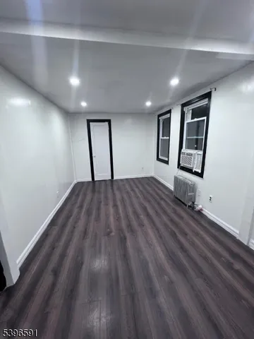 a view of a room with wooden floor and window