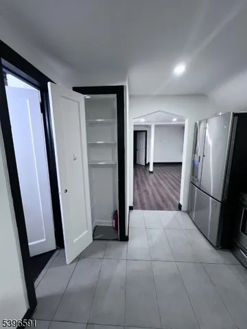 a view of a refrigerator in kitchen and a hallway