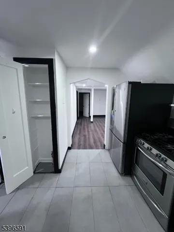 a view of a livingroom with wooden floor and kitchen space