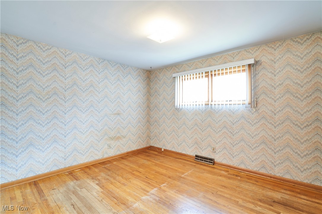 597 Hillman Road Akron, OH 44312 - Photo 13 of 22 Unfurnished room with light wood-type flooring and wallpapered walls