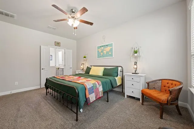 a spacious bedroom with a bed and a chandelier