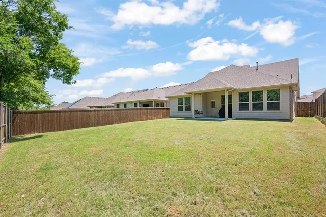 a view of house with yard outdoor seating and barbeque oven