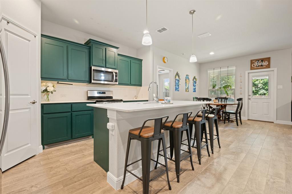 5709 Round Hl Road Denton, TX 76210 - Photo 5 of 31 a kitchen with stainless steel appliances kitchen island granite countertop a table chairs and a refrigerator