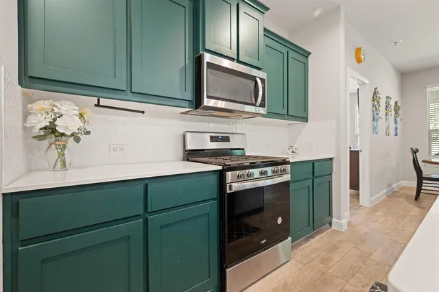 a kitchen with granite countertop cabinets stainless steel appliances and wooden floor