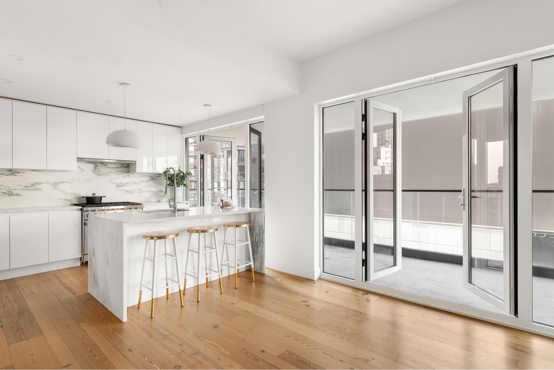 427 East 90th Street, Unit PH10 Manhattan, NY 10128 - Photo 26 of 28 a kitchen with white cabinets and wooden floor