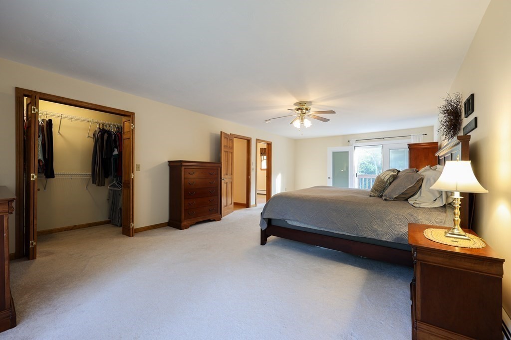 218 Lower Gore Road Webster, MA 01570 - Photo 17 of 40 a spacious bedroom with a bed and a chandelier