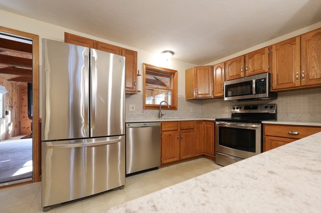 218 Lower Gore Road Webster, MA 01570 - Photo 3 of 40 a kitchen with granite countertop a refrigerator stove and microwave