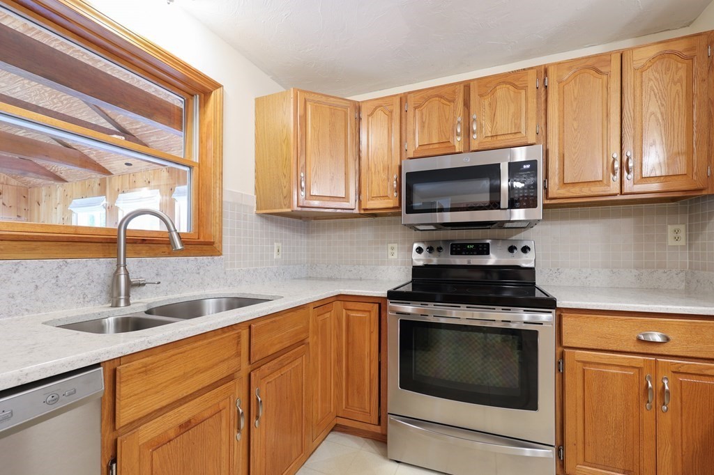 218 Lower Gore Road Webster, MA 01570 - Photo 4 of 40 a kitchen with granite countertop a stove a sink and a microwave