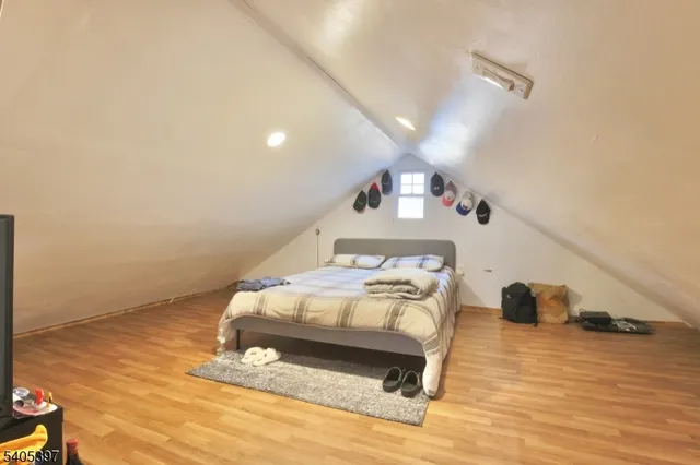a bedroom with a bed and a wooden floor