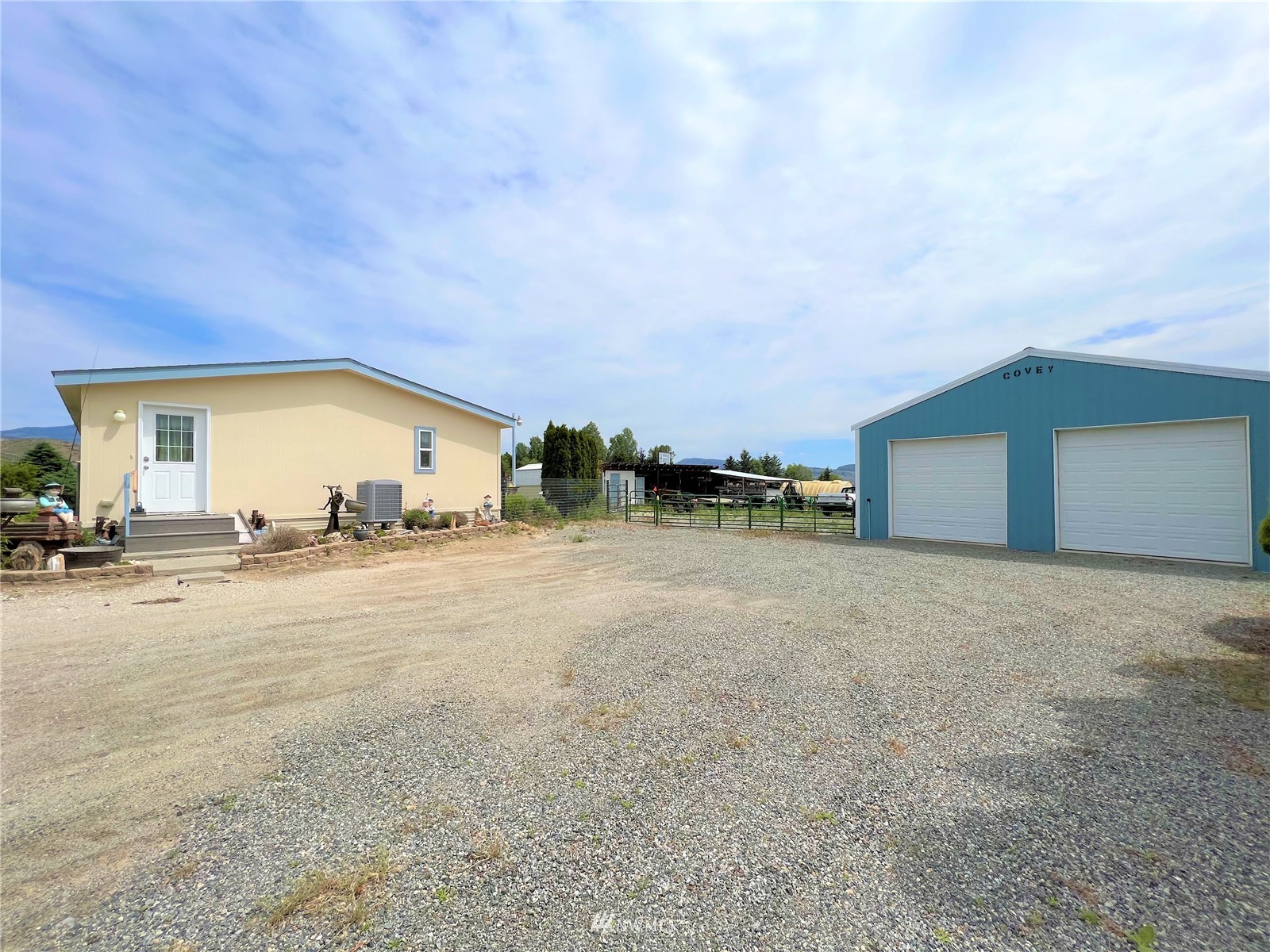 138 Miller Road Omak, WA 98841 - Photo 1 of 39 a view of a house with backyard and a garage