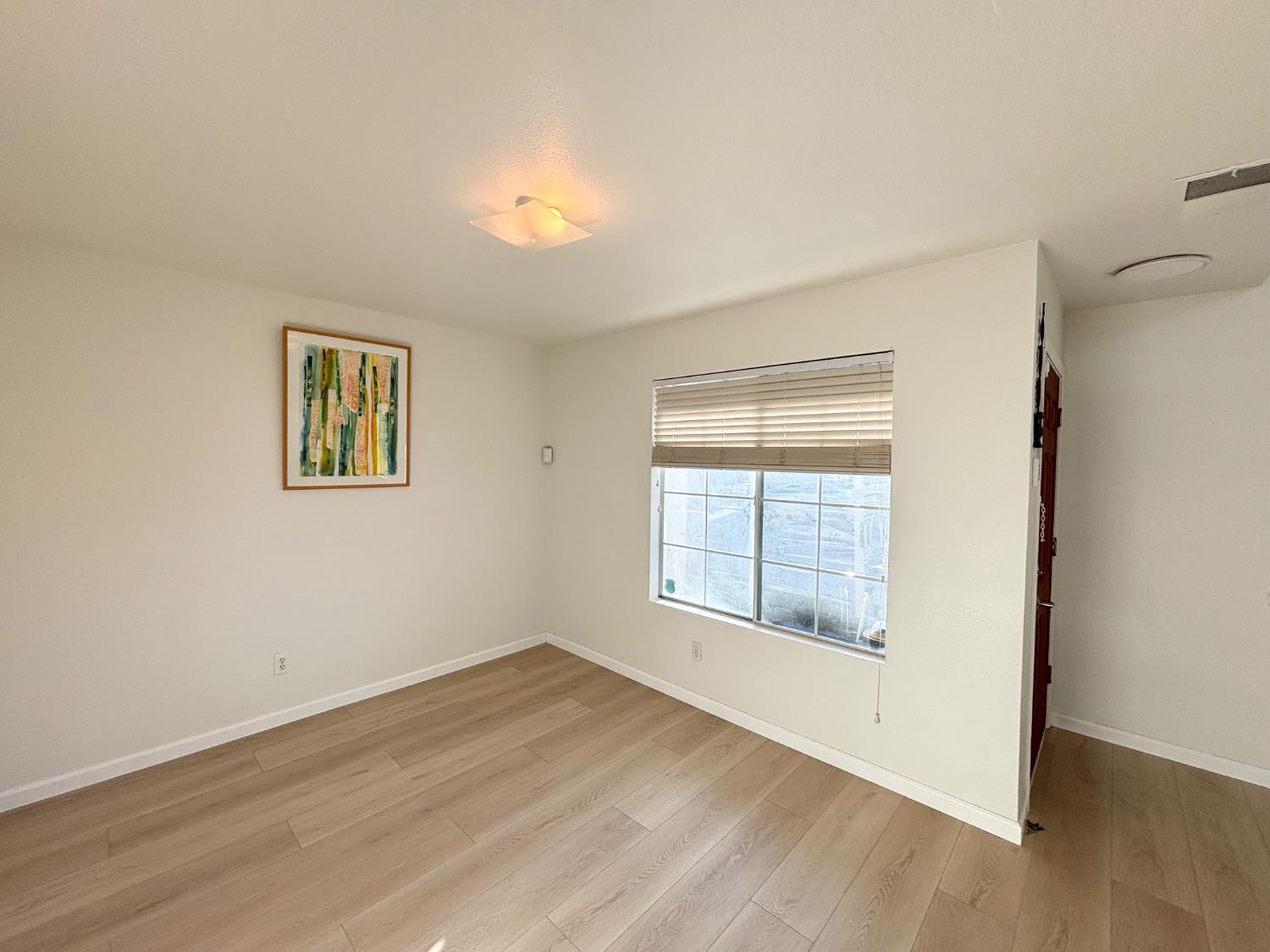 6813 Springridge Way Elk Grove, CA 95758 - Photo 6 of 26 an empty room with wooden floor and windows