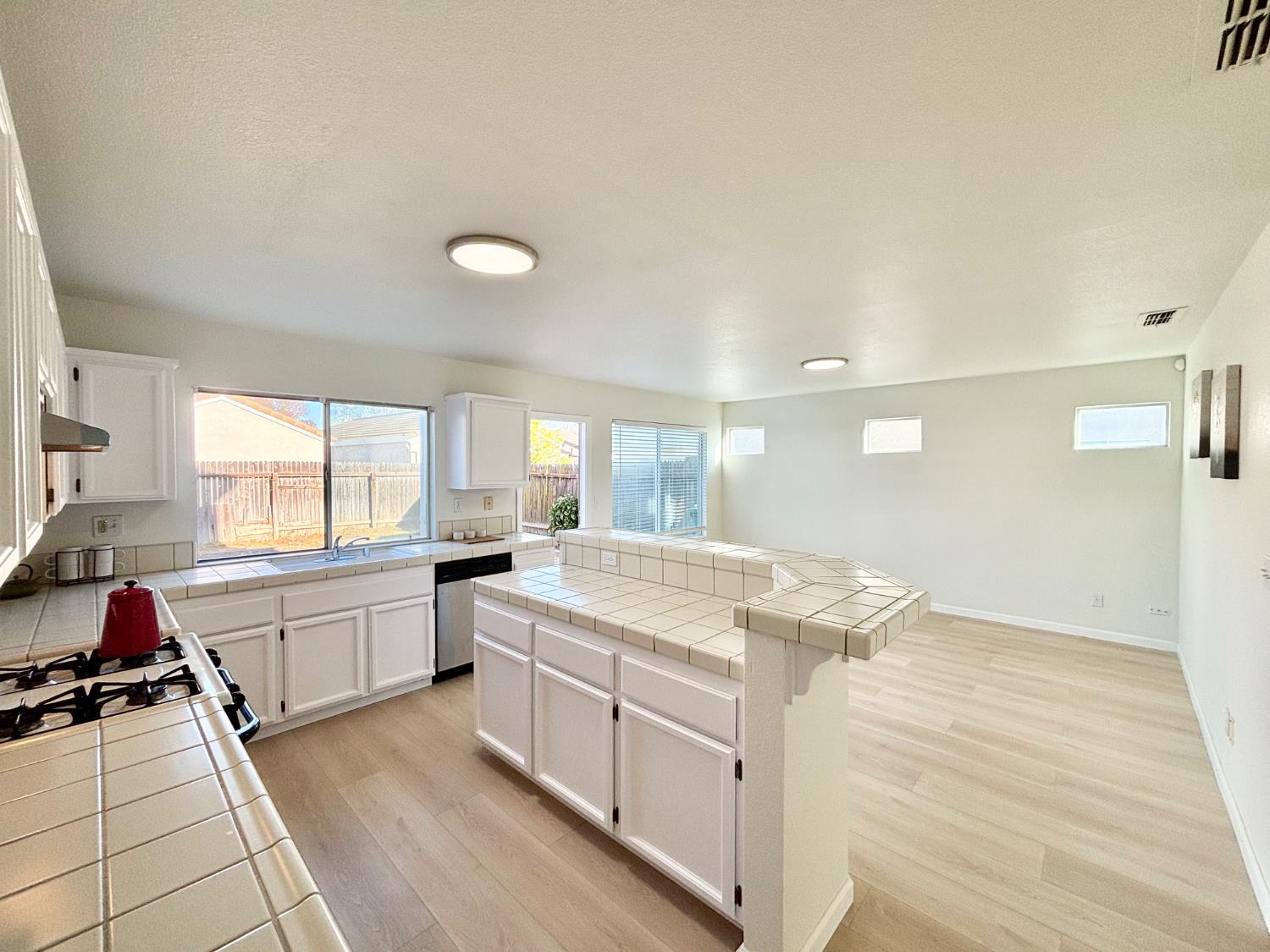 6813 Springridge Way Elk Grove, CA 95758 - Photo 7 of 26 a kitchen that has a lot of cabinets in it and wooden floors