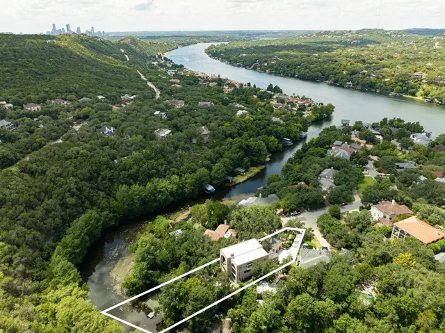 an aerial view of green landscape with trees houses and lake view