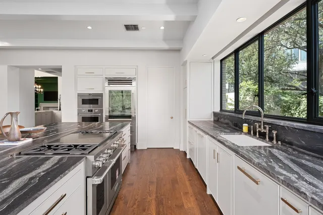 a large kitchen with granite countertop a stove and a sink