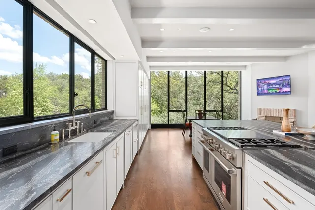 a kitchen with stainless steel appliances granite countertop a sink a stove and a refrigerator