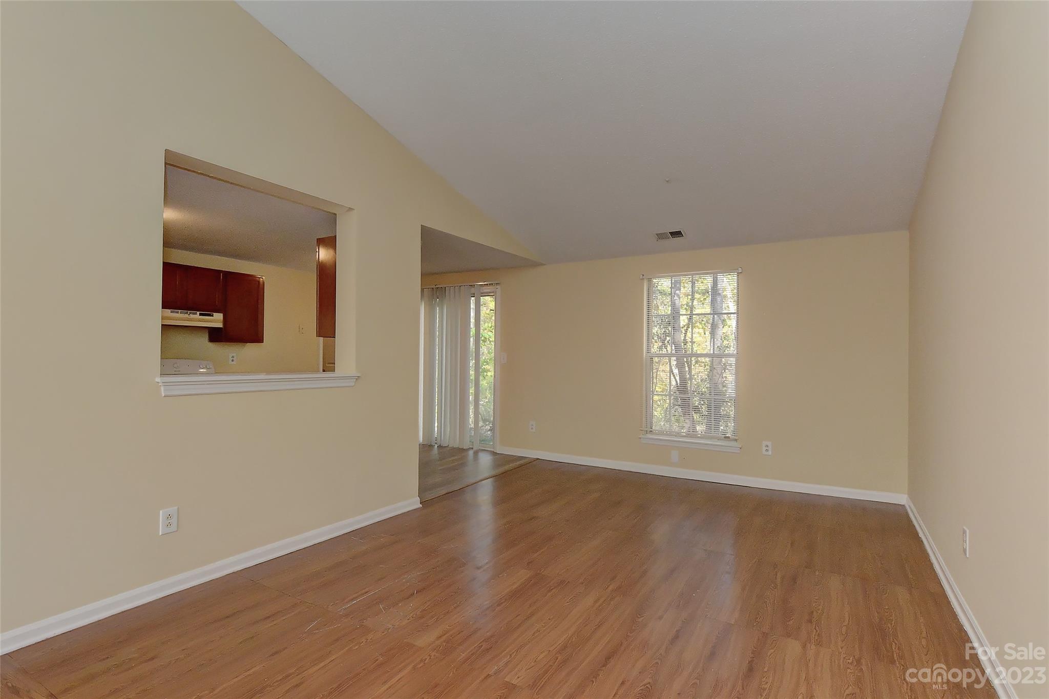 6836 Shiloh Ridge Lane Charlotte, NC 28212 - Photo 8 of 30 a view of an empty room with wooden floor and a window