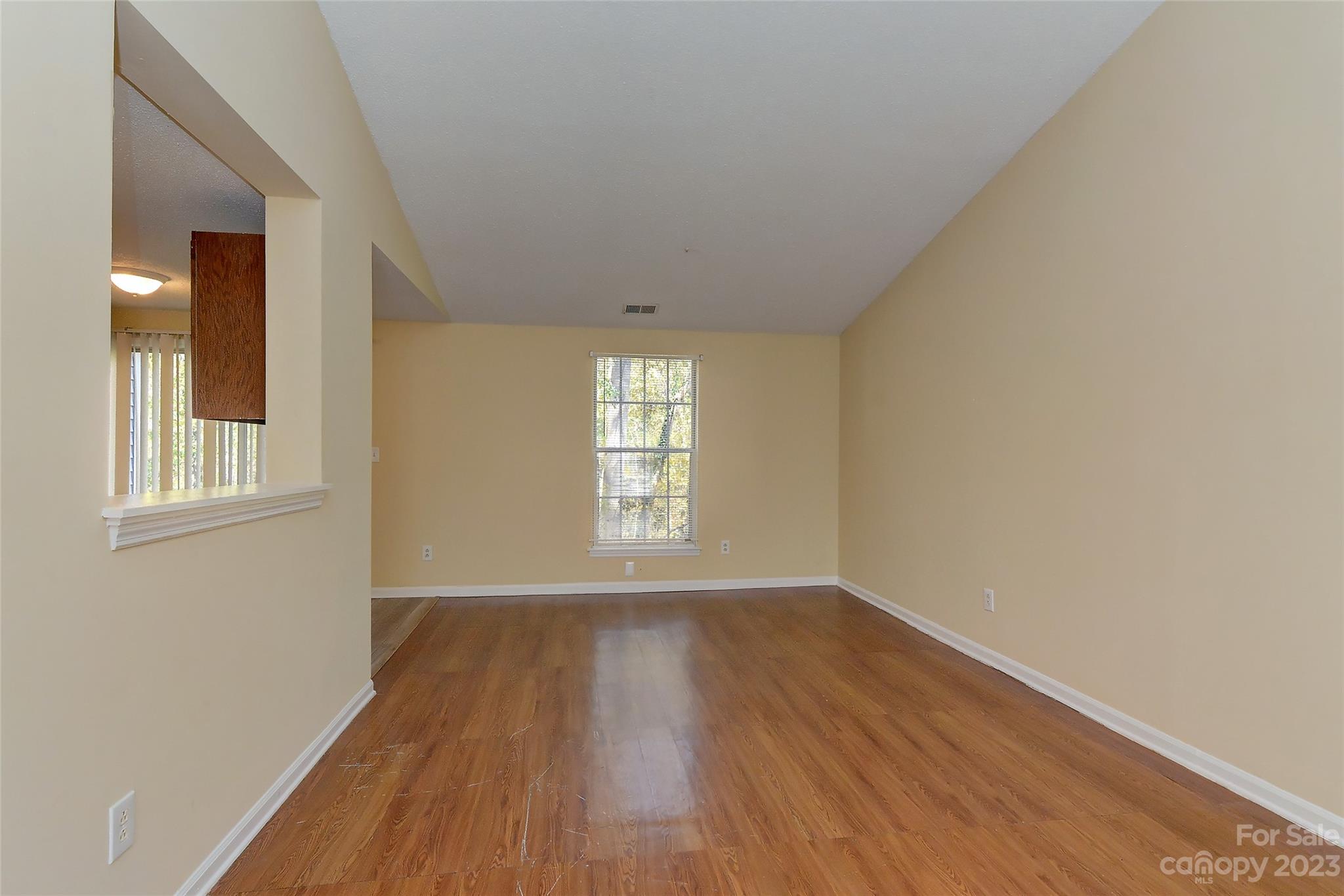 6836 Shiloh Ridge Lane Charlotte, NC 28212 - Photo 9 of 30 a view of an empty room with wooden floor and a window
