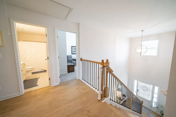 a view of a hallway with wooden floor and windows