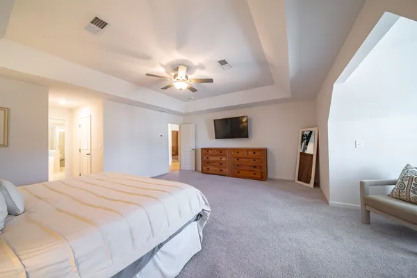 a spacious bedroom with a bed and a tv