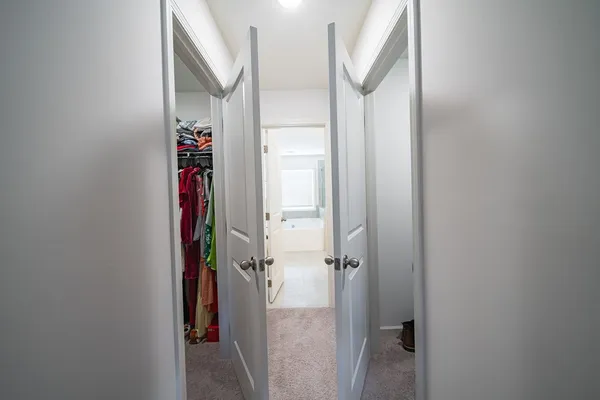 a view of a hallway with wooden floor and closet