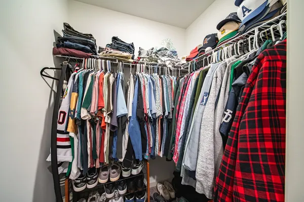a view of walk in closet with clothes and shoes
